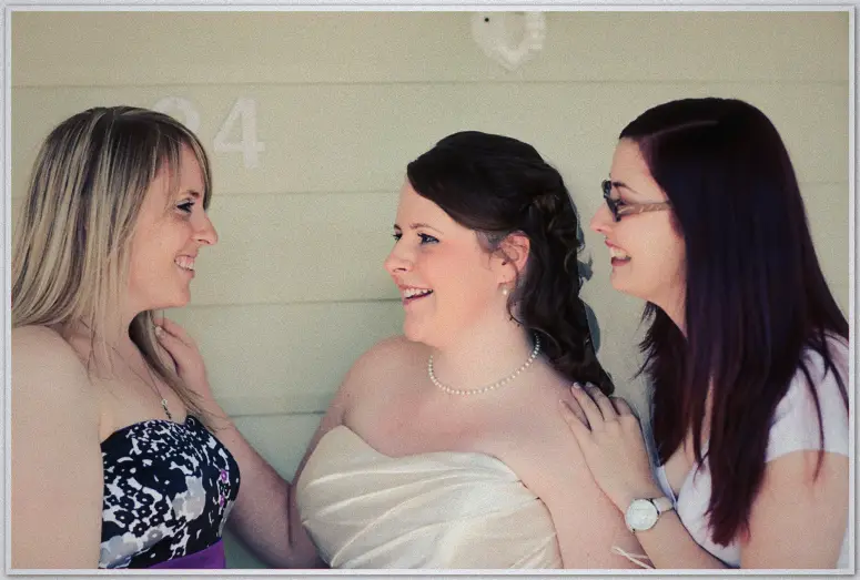 Perth Wedding Photographer - Jaimi and Kevin's wedding Laughing bride flanked by two smiling friends on the veranda of a weatherboard home before the ceremony
