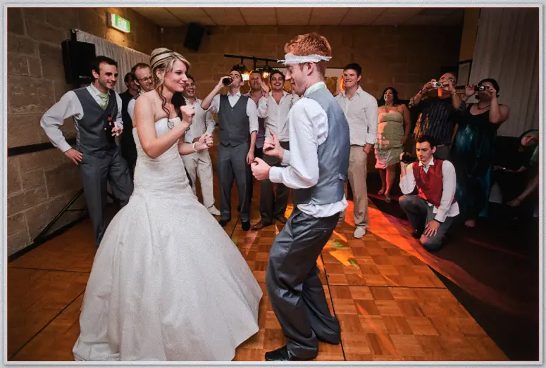 Lauren fist-pumps a red-haired groomsman with a bandaged brow as guests film the dance showdown