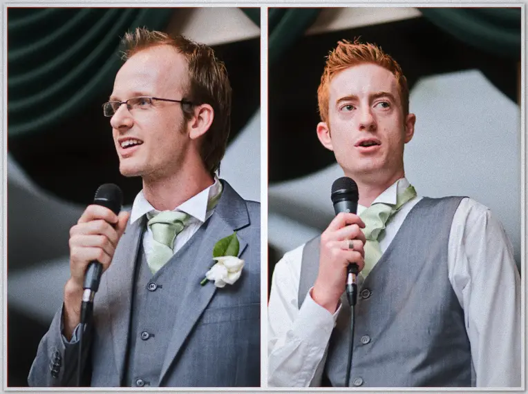 Two groomsmen in grey suits and sage ties give speeches, one laughing and one mid-sentence