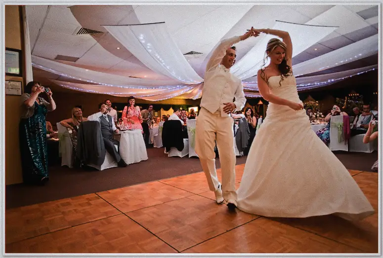Simon twirls Lauren beneath fairy-lit ceiling drapes during their first dance as guests watch on