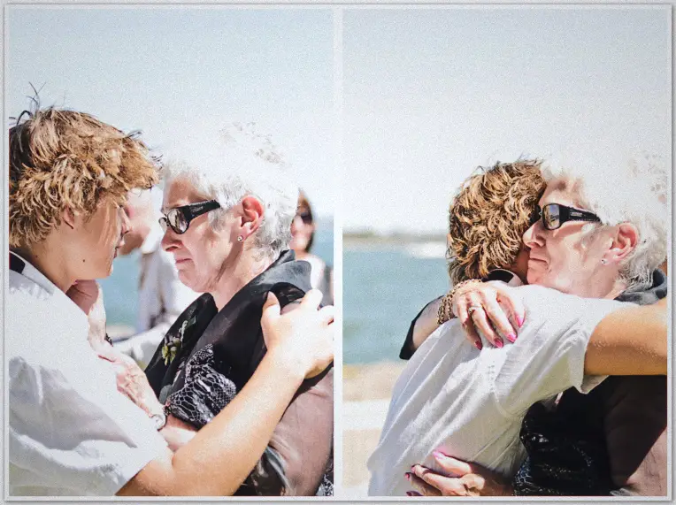 Guests hug the newlyweds by the water, candid two-frame congratulations with sunglasses