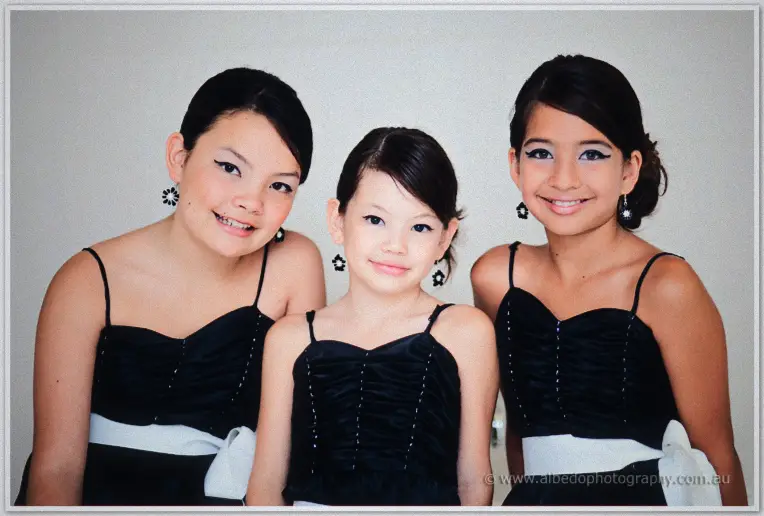 Fremantle Wedding | Charlene and Phil Three flower girls in black dresses with white sashes smile together during wedding preparations