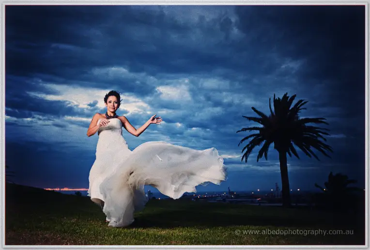 Fremantle Wedding | Charlene and Phil Charlene's gown billows in the dusk wind as she dances on the headland beneath storm clouds