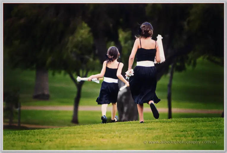 Fremantle Wedding | Charlene and Phil Two flower girls race downhill through a green park swinging their white bouquets