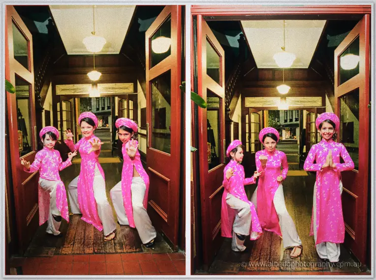 Fremantle Wedding | Charlene and Phil Three girls in pink ao dai and matching hats strike playful poses in the red doorway of a timber hall