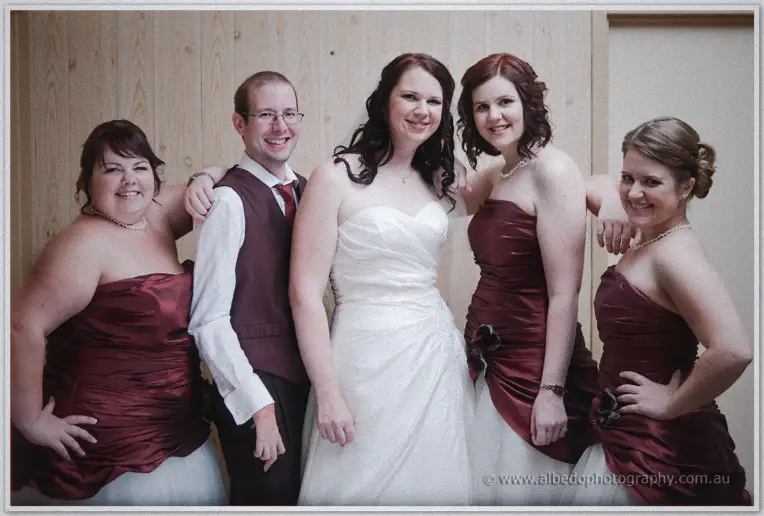 Jenn beams in her white gown among four smiling attendants dressed in matching burgundy