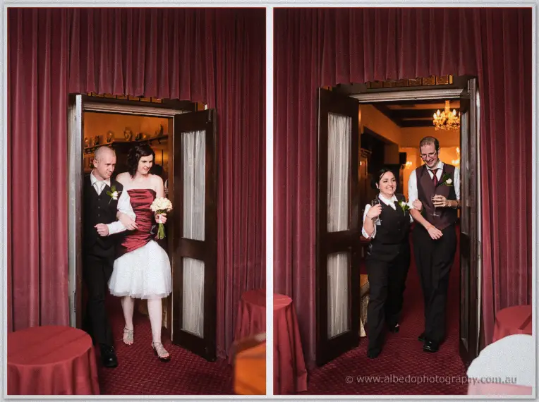 Couples step through the red velvet doors arm in arm, one pair raising wine glasses as they enter