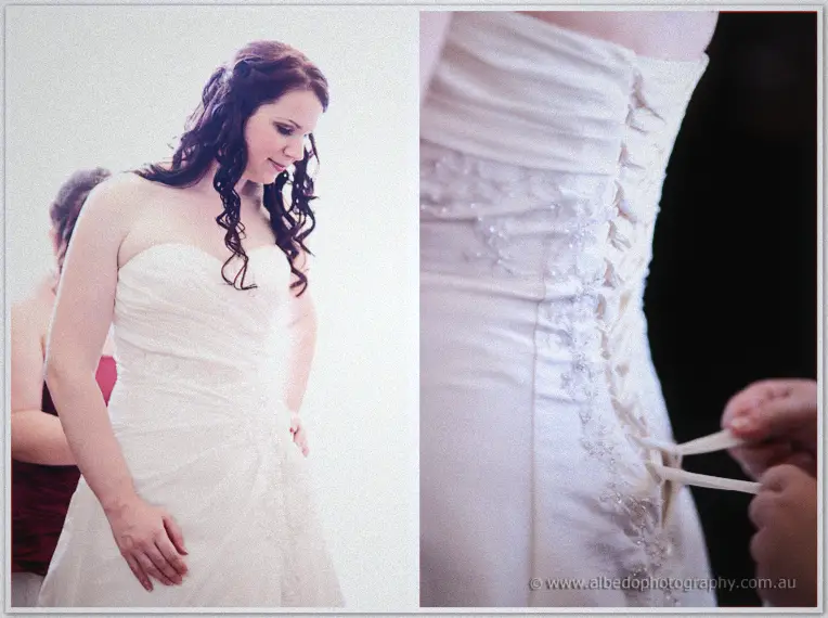 Jenn gazes down at her strapless gown while a hand threads the satin corset laces at her back