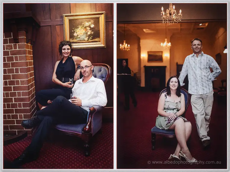 Guests pose for portraits beside the brick fireplace and chandeliers, seated in vintage armchairs
