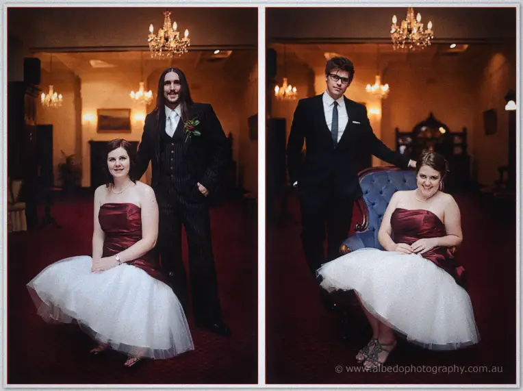 Bridesmaids in burgundy satin and tulle skirts pose with the groomsmen beneath the glowing chandeliers