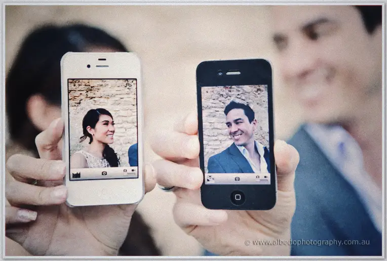 Pre wedding Fremantle | Jade and Aaron Two phones show camera previews of Jade and Aaron laughing against a limestone wall