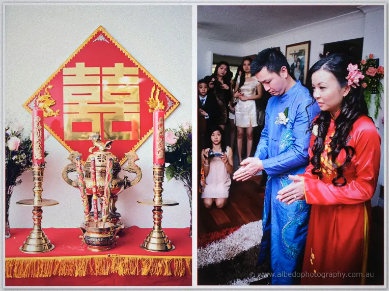 Incense and candles burn before a gold double-happiness banner as Michelle and Khoa bow at the altar.