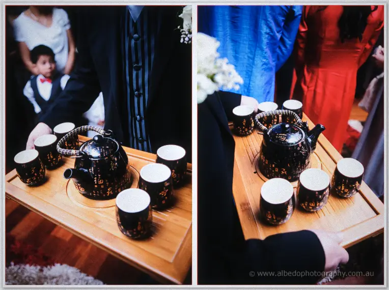 Black-and-gold tea sets on bamboo trays are carried in for the couple's traditional Vietnamese tea ceremony.