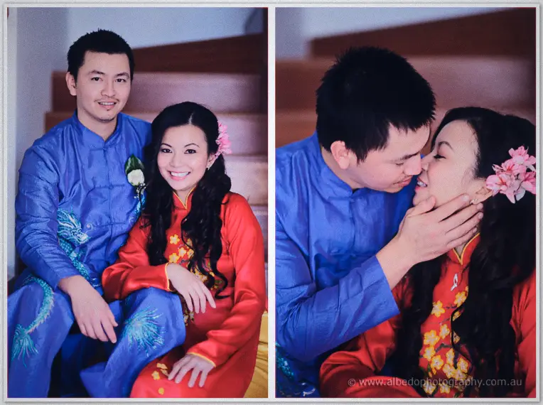 Michelle and Khoa sit close on the stairs in blue and red ao dai before he tenderly kisses her cheek.