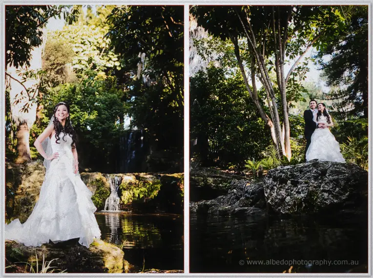 Michelle poses on a mossy rock by a fern-fringed waterfall, Khoa waiting close behind.