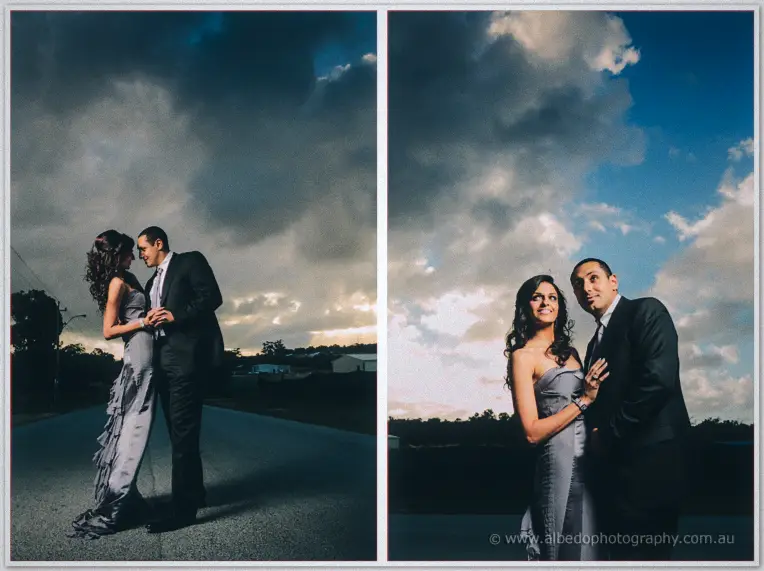 Lydia and Mina embrace on the roadway beneath a dramatic dusk sky in two romantic frames