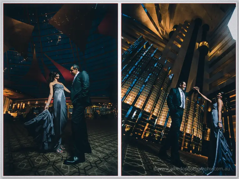 Lydia and Mina pose beneath soaring hotel architecture at night, her grey gown catching warm light