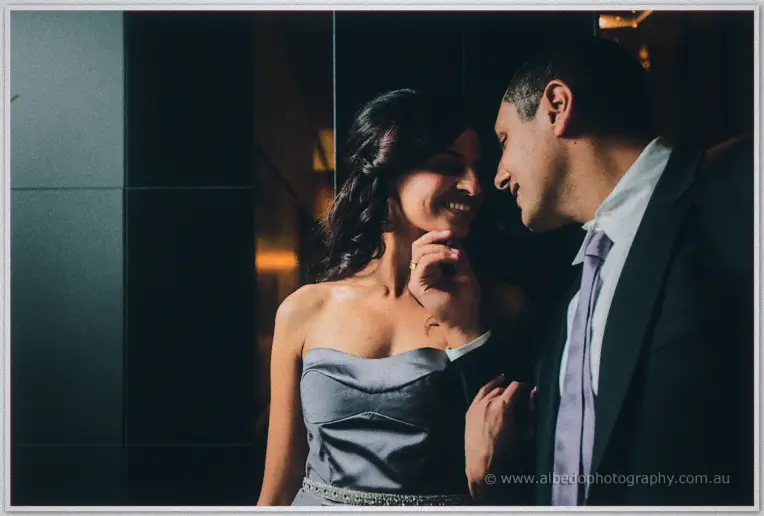 Mina tips Lydia's chin up as the pair dissolve into laughter in warm lobby light