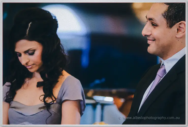 Lydia looks down pensively while Mina smiles softly beside her during the service