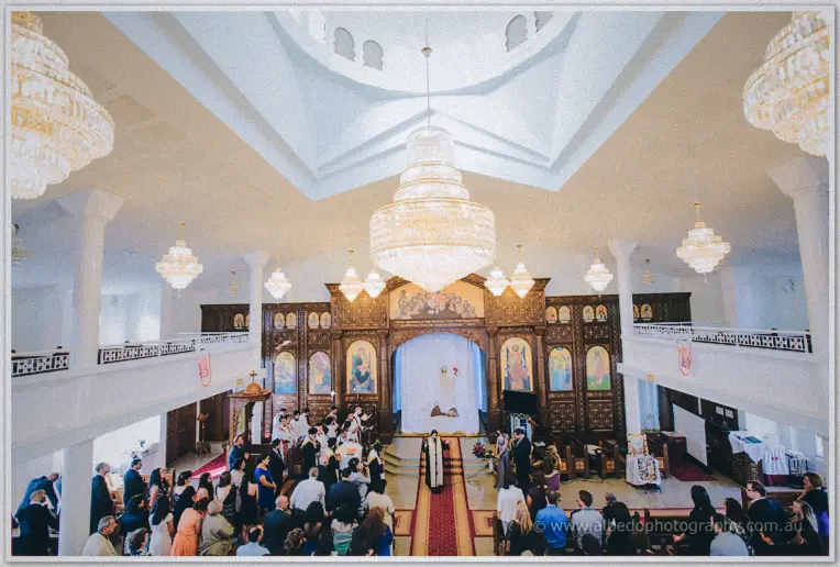 Crystal chandeliers glitter above the congregation gathered at the altar of the white church
