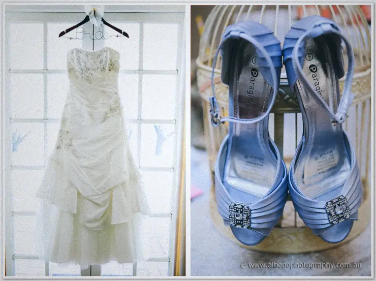 Sarah's ruched strapless gown hangs under a wire Bride hanger beside powder-blue satin heels.