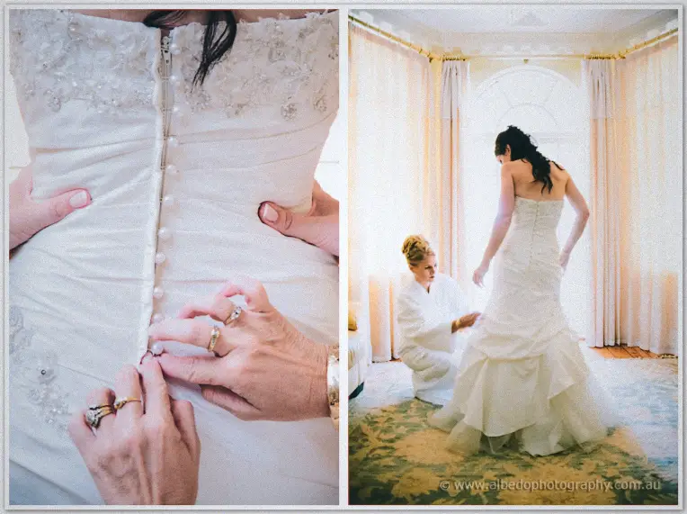 Ringed hands button pearl closures down Sarah's back beside her cascade of layered tulle.