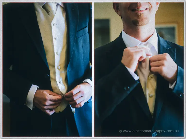 Daniel grins as he buttons his cream waistcoat and settles his tie over a white shirt.
