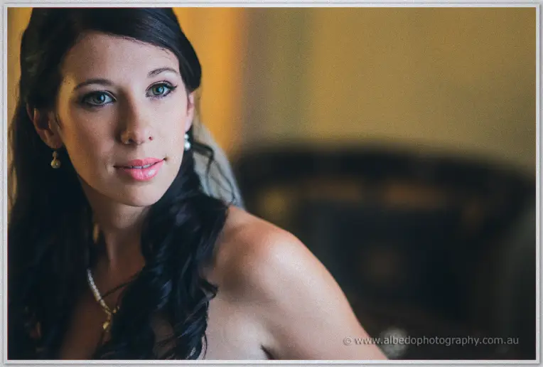 Sarah glances back over her bare shoulder, green eyes bright, in warm Brookleigh light.