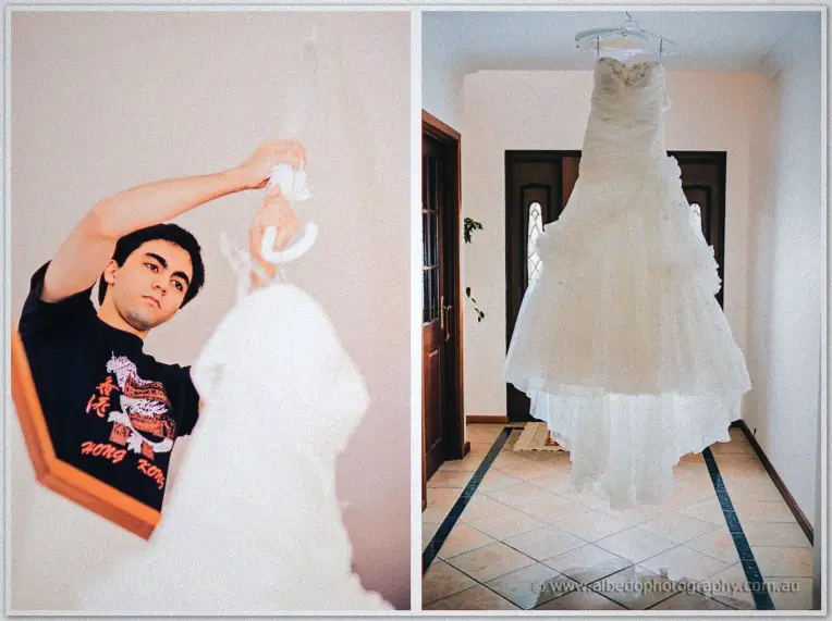 A friend lifting Sarah's ruffled strapless gown from its hanger in the sunlit hall