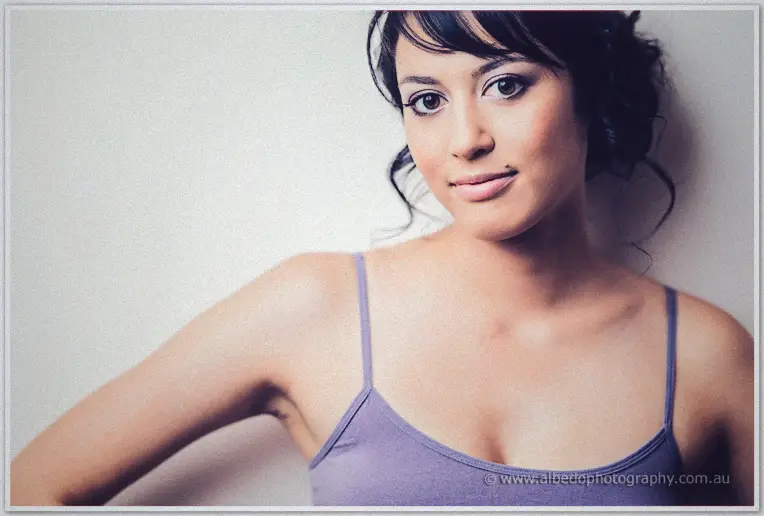 Soft close-up of bride Sarah in her lilac camisole, upswept hair and smoky eyes in window light
