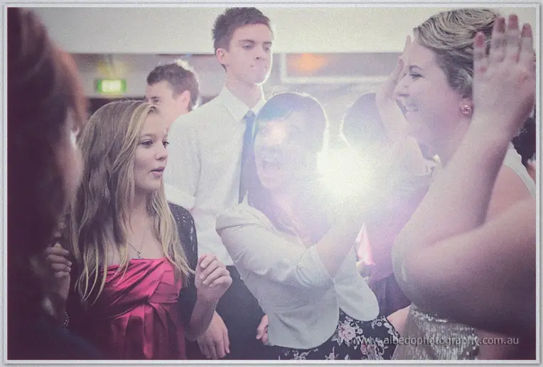 Young guests rock out in berry and black dresses, flare flashing between them