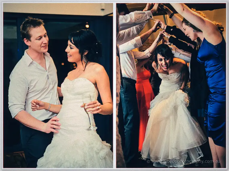 Dancing bride twirling under guests' raised arms and laughing beside her groom in white shirt at the reception