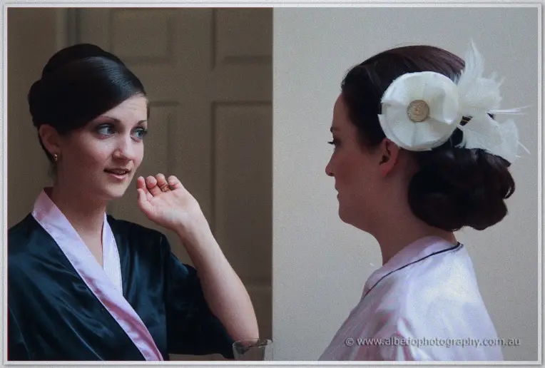 Bridesmaids chatting as the bride's feathered hair flower is finished