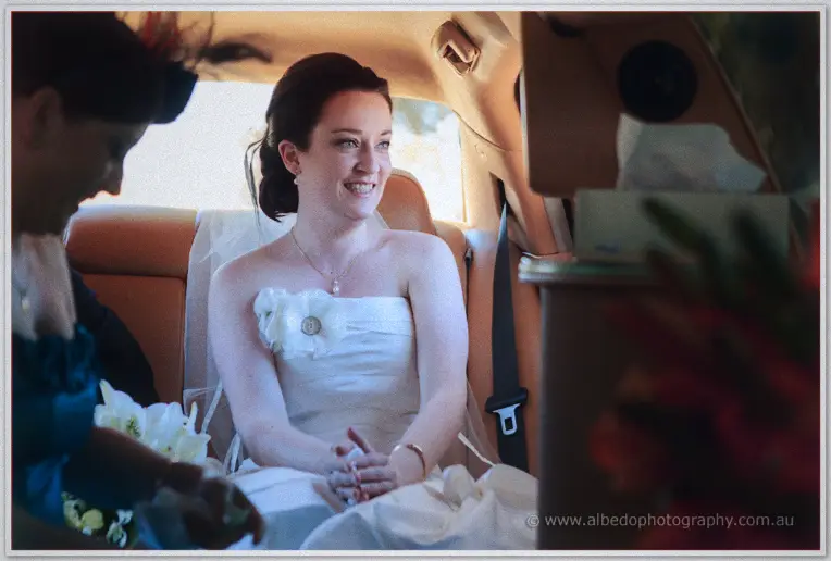 Felicity smiling on the limousine's cream leather seats as a bridesmaid leans in