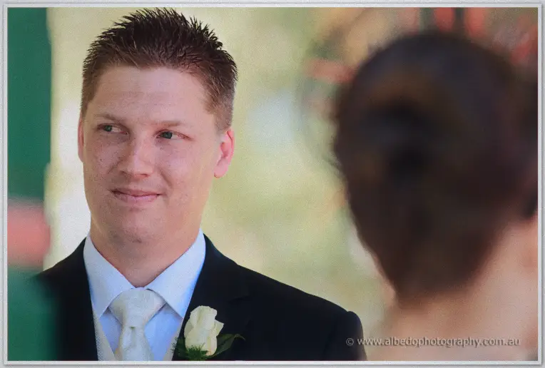 Close-up of Phil watching his bride approach with a soft smile