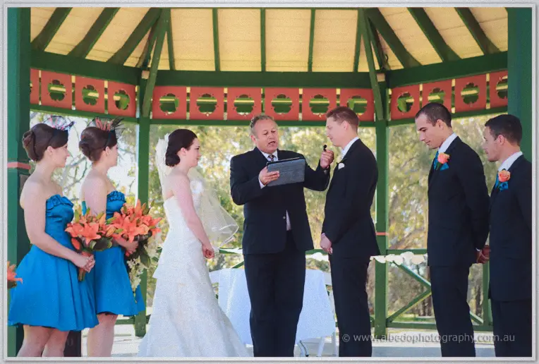 Felicity and Phil facing the celebrant with their party inside the gazebo