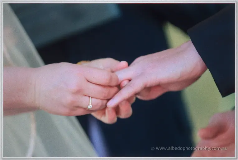 Close-up of Phil sliding the diamond ring onto Felicity's finger