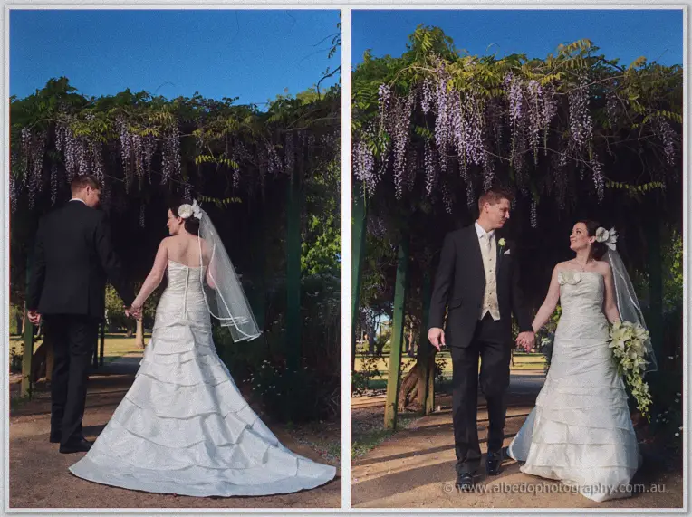 Two frames of the couple strolling under Stirling Square's wisteria archway