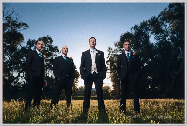 Phil and his groomsmen striking dusk poses in the backlit meadow