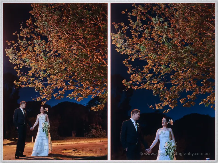 Felicity and Phil hold hands beneath a street-lit tree with orange leaves against a night sky
