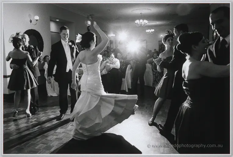 Felicity spins so her tiered gown swings out while Phil beams behind her on the dance floor