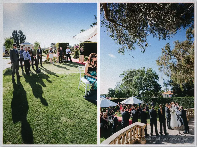 Guests stand on the lawn and by the balustrade as the ceremony unfolds under the trees