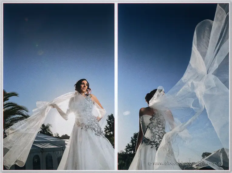 Wind whips Jenna's veil skyward against a deep blue evening sky as she lifts her train