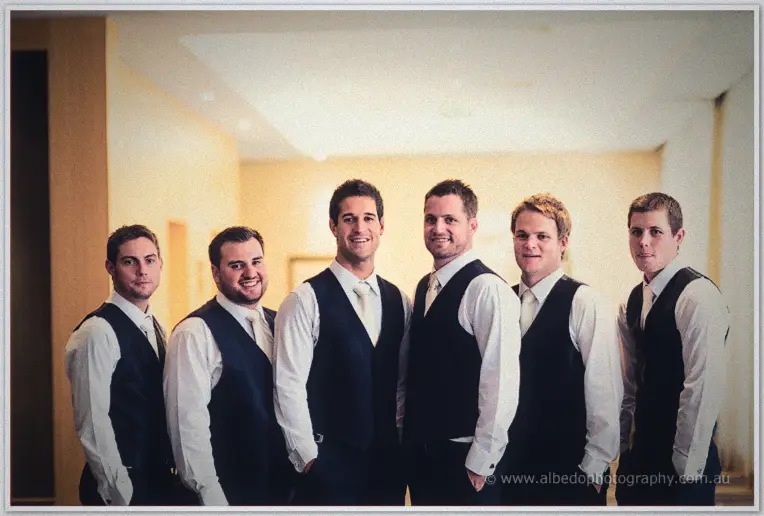 Nathan stands tall with his five groomsmen lined up in matching vests and ties