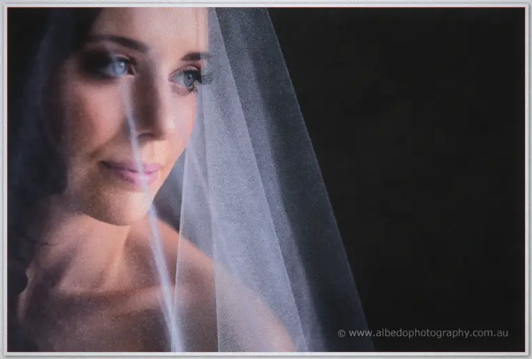 Moody close portrait of Karis gazing beneath a translucent veil