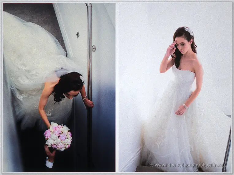 Karis gathers her gown descending a stairwell and pauses composed on bright stairs