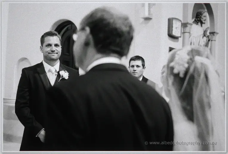 Nathan smiles as Karis arrives beside her father at the altar in monochrome