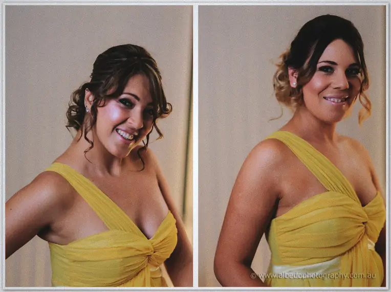 Two smiling bridesmaids in yellow one-shoulder dresses posing cheek to cheek indoors