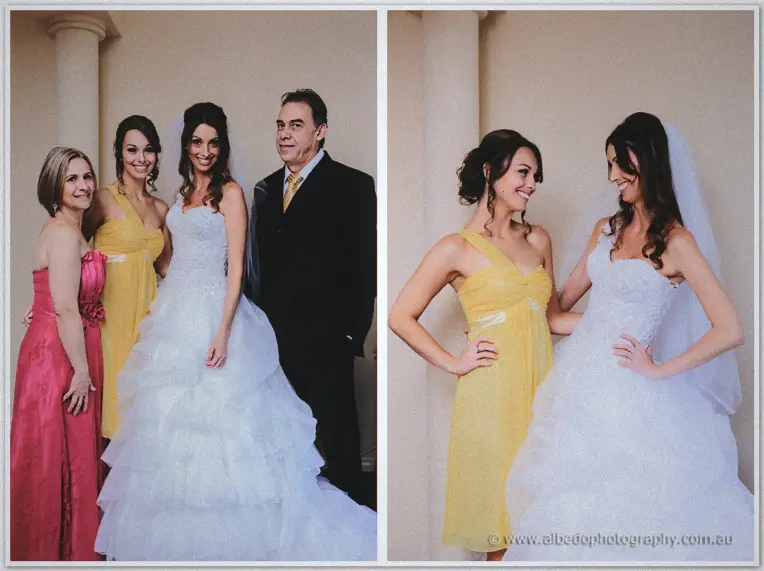Bride in a ruffled gown posing with her parents and bridesmaid beneath a pale column
