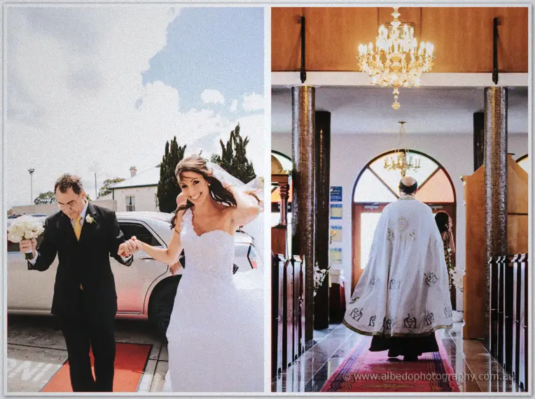 Smiling bride arriving with her father beneath a blue sky and a priest by candlelit chandeliers